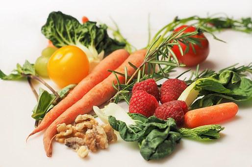 Das Bild zeigt Gemüse wie Karotten, Tomaten, Kohl und Früchte wie Himbeeren, Nüsse. 