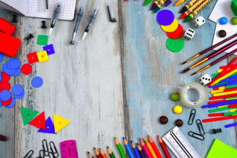 In einem Kreis angeordnet, liegen Materialien, die für Lernen verwendet werden können. Wie zum Beispiel Bleistifte in verschiedenen Farben, Lineal, Radiergummi, Büroklammern, Würfel, Plättchen und einiges mehr. 